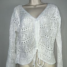 a mannequin wearing a white shirt with crochet on the front and back