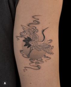 a black and white photo of a bird on someone's arm with water swirling around it