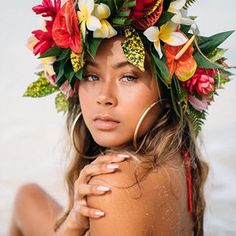 a woman with flowers in her hair wearing a flower crown on her head and body