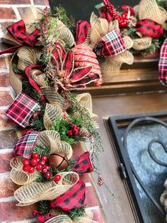 two christmas wreaths hanging from the side of a brick wall next to a fire hydrant