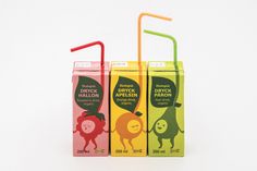 three different flavors of juice in boxes with straws on the top and one has an orange, green, and red plastic straw