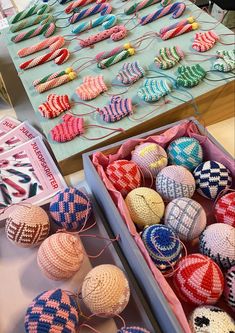 two boxes filled with knitted balls next to each other on top of a table