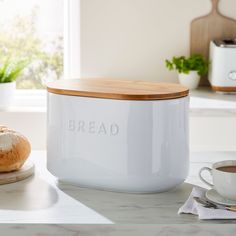 a loaf of bread sitting on top of a counter next to a cup of coffee