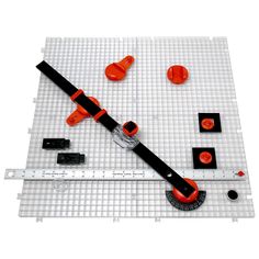 an orange and black tool is laying on a white mat with other tools around it