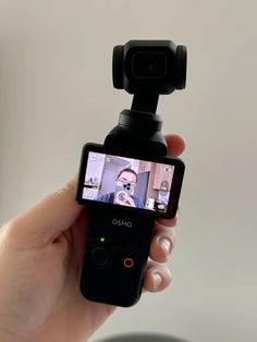 a person holding up a cell phone to take a selfie with their camera attached