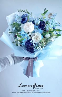 a bouquet of blue and white flowers is being held by someone's hand with the words lemon grass written on it