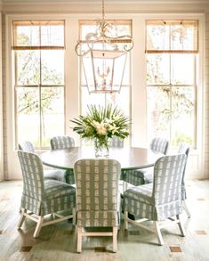 a dining room table with blue chairs and a chandelier