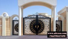 an iron gate in front of a building with pillars and arches on the sides that lead into it