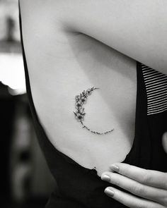 black and white photo of a woman's stomach with a flower tattoo on it