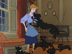 a woman standing next to a black dog in a living room