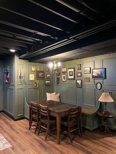 an empty room with wooden tables and pictures on the wall, along with two lamps