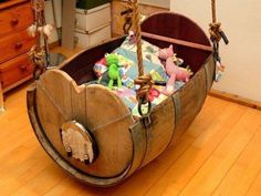 an old wooden baby's cradle with stuffed animals in it and hanging from ropes