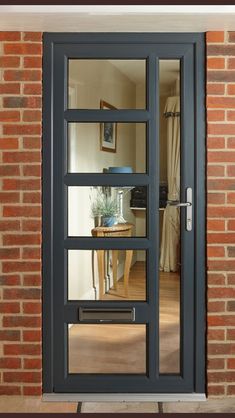 an open glass door in front of a brick wall