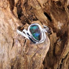 Modern elegance characterizes this natural Australian boulder opal ring. The silver ring is artfully shaped and adapts to the free form shape of the stone. This gives the ring its special expressiveness. Green plays of light shine on the brown ironstone matrix. A beautiful piece of jewelry that can be worn every day and is guaranteed to be unique! Opal type: Boulder opal Origin/place of discovery: Queensland, Australia Silver 925 silver  Color: Brown-green Cut: Freeshape, 10,3x6,8mm Ring size: 5 Sterling Silver Freeform Rings As Gifts, Nature-inspired Opal Ring Gift, Green Play, Boulder Opal Ring, Australian Boulder Opal, Wave Ring, For Her Gifts, Opal Ring, Boulder Opal