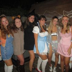 a group of young women standing next to each other wearing costumes and posing for the camera