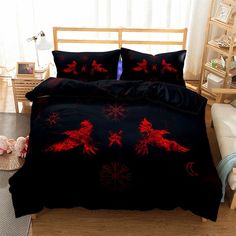 a bed covered in black and red comforters with horses on them, sitting next to a window