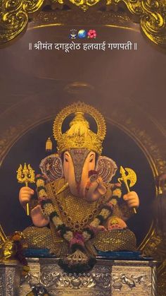 an elephant statue sitting on top of a wooden table next to a gold framed wall