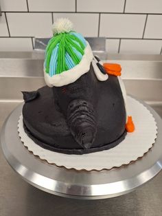 an elephant wearing a hat on top of a cake