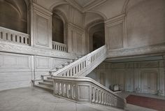 a staircase in an old building with white walls