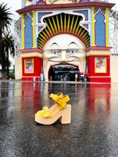 a pair of yellow shoes sitting on the ground in front of an amusement park building