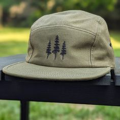 🌲🌲 5% of profits donated to preservation 🌲🌲  Gear up for your next adventure with our olive green tree 5 panel hat, the ultimate camp hat! Crafted from 100% cotton, this hat's flat bill keeps you cool and shaded as you conquer trails, lounge by the campfire, or explore the great outdoors. Your new adventure-ready essential! This hat is olive green with black embroidered trees on the front. Embroidery is custom designed by the shop owner, Alyssa, stitched on front. - 100% cotton - 5 Panel, Camp Hat - Head circumference: 19⅝″-22½″ - Flat Bill - Nylon adjustable strap - Custom embroidery, on the front center - Hand wash, dry flat - Olive green hat - The perfect hiking gift, camping gift and nature gift! Olive Green Hat, Camper Hat, Camp Hat, Five Panel Hat, Hiking Hat, Flat Brim Hat, Five Panel, 5 Panel Hat, Hiking Gifts