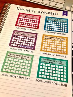 a planner with the dates and times for each month on it, sitting next to a computer keyboard