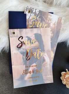 two save the dates cards sitting on top of each other next to flowers and a bouquet