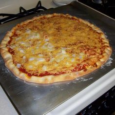 an uncooked pizza sitting on top of a stove