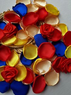 a pile of red, yellow and blue flowers on top of each other with leaves