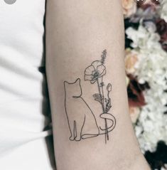 a cat and flower tattoo on the left inner arm, which is drawn in black ink