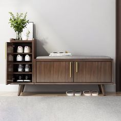 a wooden cabinet sitting next to a wall with a potted plant on top of it