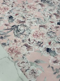 a pink floral print fabric with white and grey flowers on the bottom half of it