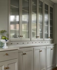 a kitchen with white cabinets and wood floors