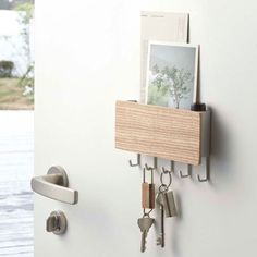 there is a key holder on the wall with keys hanging from it's hooks