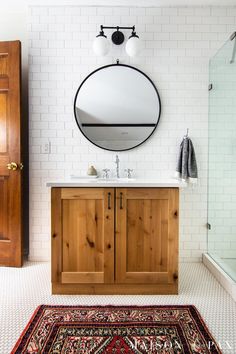 a bathroom with a rug, sink and mirror