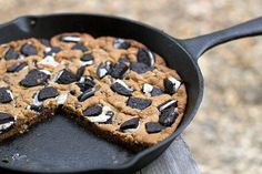 a chocolate chip cookie in a cast iron skillet with one slice missing from it