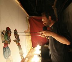 a man standing in front of a painting holding a microphone