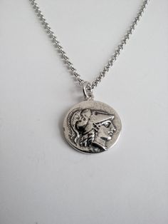 Varouxi Pendant Goddess Athena Silver 925 a very nice pendant in silver 925 a souvenir from ancient Greece accompanied by a silver chain 925 length 45cm Diameter coin:18mm Weight coin:5,0gr total weight:9,2gr Metal:silver 925 MACEDONIAN KINGS. Alexander the Great. 323-317 B.C. E. Head of Goddess Athena O.The Goddess Nike with laurel wreath All creations are specially designed, hand cast of solid silver, and individually polished Black oxidised background to enhance ( coin ) symbols Made entirely Classic Silver Necklace With Coin Pendant, Silver Medallion Necklace In Symbolic Style, Symbolic Sterling Silver Pendant Medallion Necklace, Silver Round Coin Necklace, Sterling Silver Round Pendant Medallion Necklace As Gift, Engraved Sterling Silver Round Medallion Necklace, Engraved Round Sterling Silver Medallion Necklace, Engraved Sterling Silver Coin Necklace, Engraved Sterling Silver Round Coin Necklace