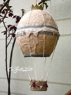 a paper hot air balloon hanging from a tree