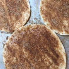 three flat breads sitting on top of a pan covered in seasoning powdered sugar