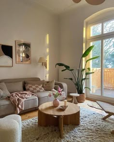 a living room filled with lots of furniture and a large window covered in light coming through