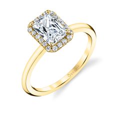 a yellow gold ring with a square cut diamond surrounded by small round brilliant pave diamonds