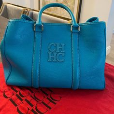 Carolina Herrera Turquoise Leather Matteo Tote. Bag Is In Very Good Condition. I’ve Added As Many Pics As I Can To Show All Angles But If You Want More Pics Please Let Me Know And I’m Happy To Provide More. Comes With Dust Bag. The Handles Have Some Wear And Tear But In Good Condition Overall. Some Wear And Tear On The Corner Edges As Well Which I Have Shown In The Pics. This Stunning Turquoise Tote Is From The House Of Carolina Herrera. Crafted From Leather, And Lined With Fabric On The Insides, The Bag Features Dual Rolled Top Handles, With Silver Hardware. Luxury Turquoise Travel Bags, Turquoise Leather Shopping Bag, Chic Turquoise Crossbody Bag, Chic Turquoise Shoulder Bag For Shopping, Turquoise Top Handle Travel Bag, Turquoise Top Handle Shopping Bag, Luxury Blue Satchel With Leather Handles, Turquoise Top Handle Bag For Shopping, Chic Turquoise Leather Bag