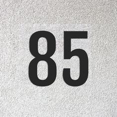 the number eighty five is shown in black on a white wall