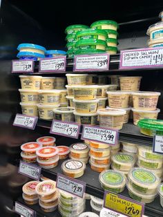 the shelves are filled with different types of ice creams and yogurts for sale