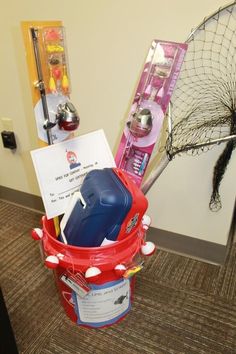 a bucket filled with items sitting on top of a carpeted floor next to a net