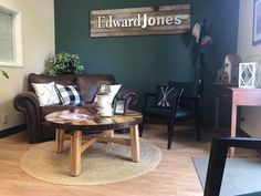 a living room filled with furniture next to a wooden table and wall mounted wood sign