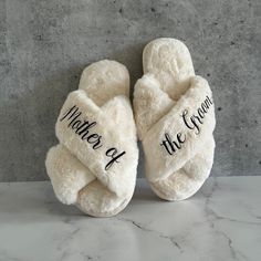 a pair of white slippers with the words mother of the groom written on them