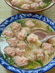 two bowls filled with dumplings and broccoli on top of a wooden table