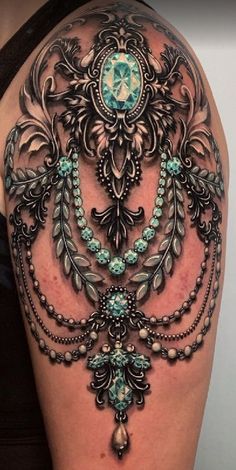 the back of a woman's shoulder with an intricate tattoo design on her arm